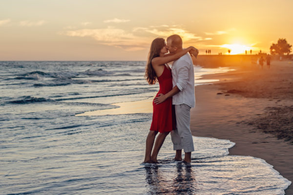 A honeymoon couple on a tropical beach at sunset